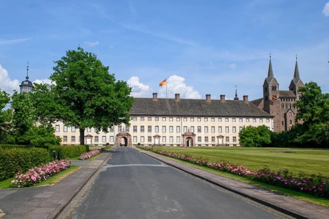 View across driveway with flower-lined street to Corvey Castle and Monastery, Höxter, North