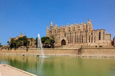 Cathedral of St Mary of La Seu, in front of it artificial lake water basin in Parc de la Mar with