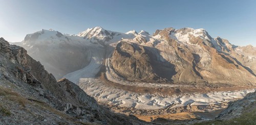 At dawn, the sun bathes the peaks of the Alps in a golden light and reveals stunning glaciers and