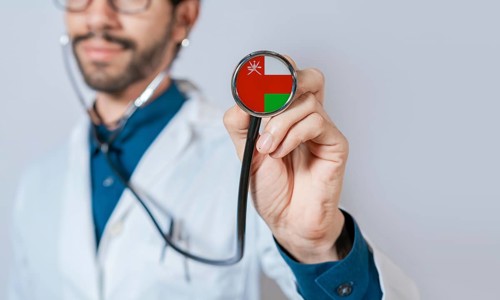 Doctor holding stethoscope with Oman flag. Oman health and care concept, Oman flag on stethoscope