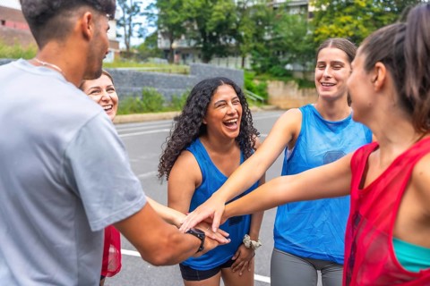 Young soccer players are gathering in a circle, joining their hands together, symbolizing their