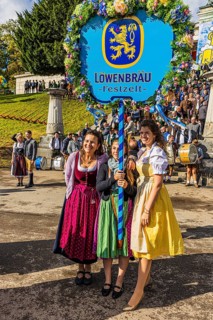 The landlady of the Löwenbräu festival tent in company with flower-decorated table, Wiesnwirte