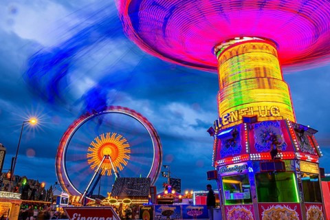 Illuminated chain carousel in motion, behind the Ferris wheel in motion, Festwiese, Theresienwiese,