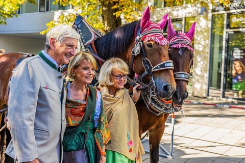 Actress Uschi Glas with man Dieter Hermann and wine tent landlady Doris Kuffler in front of a