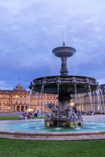 Evening atmosphere at Schlossplatz Stuttgart. View of the New Palace. Illuminated fountain bowl at