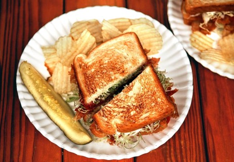 BLT, bacon, lattuce, tomato, with toast cucumber and chips on a paper plate, served in a diner,