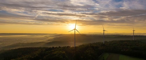 A wide panorama with wind farms at dawn, the sun rises over the landscape, near Schorndorf,