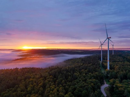 Wind turbines with a winding road through a forest area at sunrise, near Schorndorf, Remstal,
