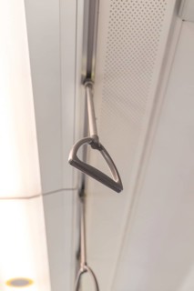Close-up of the grab rails on the ceiling of a train, battery Electric train with green