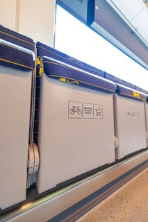Train interior with folding seats and bright lights, battery Electric train with green electricity,