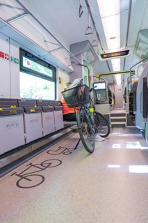 A modern designed train area for bicycles with seated cyclist, battery Electric train with green