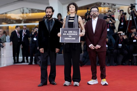 Venice, Italy - 1 September 2025: Charlie Kaufman, Eva H.D. and Josef Akiki with a sign reading -