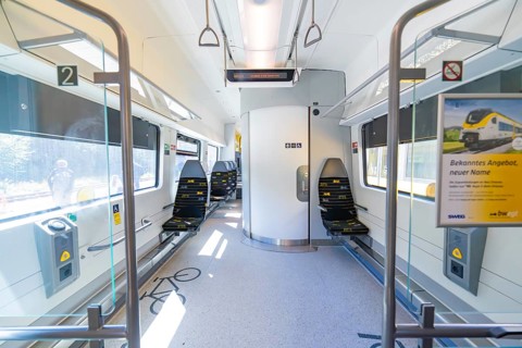Interior of a modern train with blue seats and bright ambience, battery Electric train with green