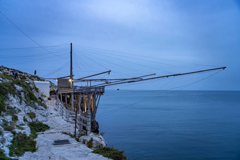 Historic pile dwelling of the fishermen Trabucco on the coast of Vieste at dusk, Gargano, Apulia,