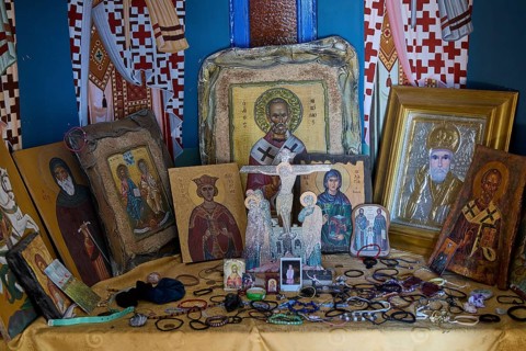 Table full of orthodox icons of various saints in an interior, Agios Nikolaos Chapel, harbour,