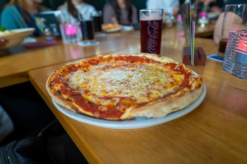 Pizza with cheese and tomato sauce on a plate in a restaurant, Lake Constance, Germany