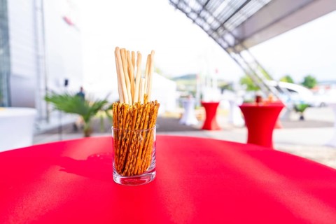 A jar of breadsticks stands on a red table at an outdoor event, Lake Constance, Germany