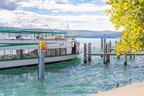 Boat approaching a jetty on a lake on a sunny day, Lake Constance, Germany