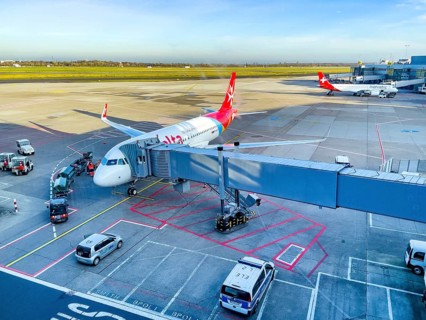 View of passenger aircraft of Air Malta at finger bridge for boarding disembarking passengers in