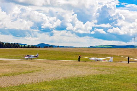 View of left single-engine light aircraft Robin DR400 as tow plane for right glider Glider pilots