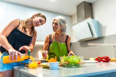 Two women preparing a healthy meal in a contemporary kitchen, focusing on fresh ingredients like