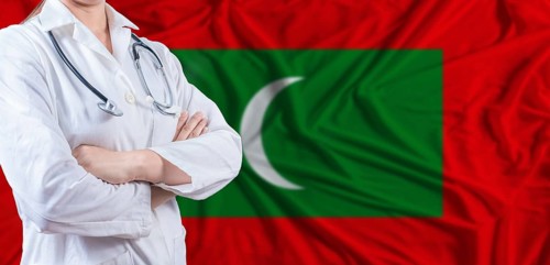 Doctor with crossed arms on Maldives flag. Maldivian health and care concept. Female doctor on