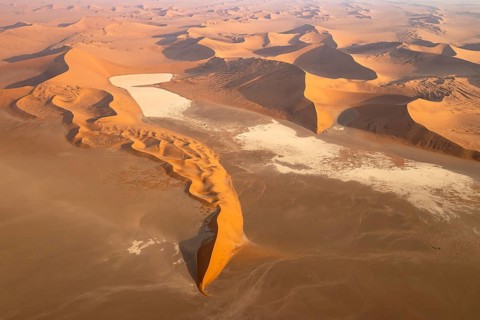 Sand dunes and dry pans in the Namib Desert. In the evening. Aerial view. Namib-Naukluft Park,