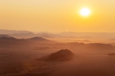 Arid plains and isolated mountain ridges at the edge of the Namib Desert. At sunrise. Aerial view