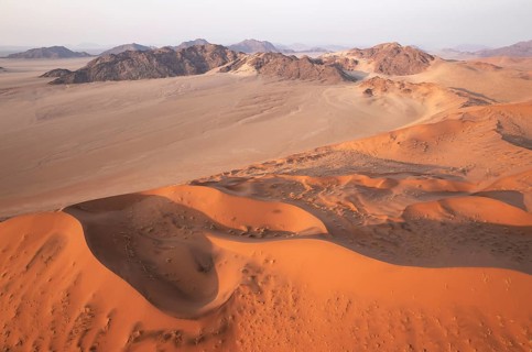 Sand dunes and mountain ridges in the Namib Desert. In the evening. Aerial view. Namib-Naukluft
