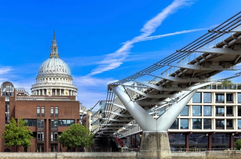 Millennium Bridge in London city financial business center, view from the River Thames