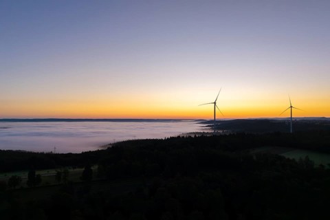 Darker morning sky with wind turbines and fog in the foreground, near Schorndorf, Remstal,