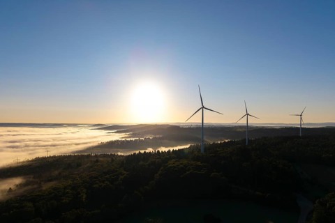 Towering wind turbines at sunrise over a foggy forest, near Schorndorf, Rems-Murr district,
