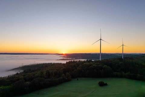 Sunrise over a foggy landscape with visible wind turbines, near Schorndorf, Remstal,