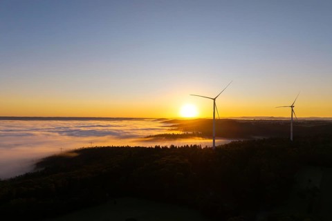 Wind turbines over foggy fields and hills at sunrise, near Schorndorf, Rems-Murr-Kreis,