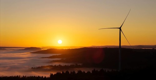 Wind turbine in front of a picturesque sunrise over a misty landscape, near Schorndorf, Remstal,