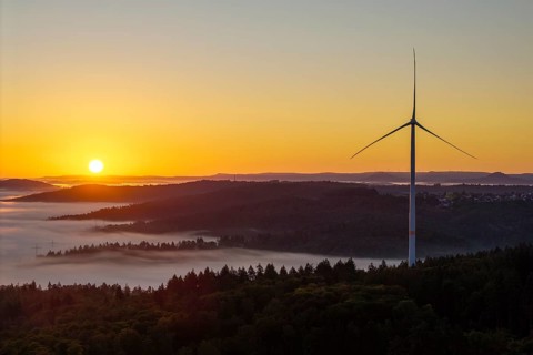 Wind turbine at sunrise over a misty hilly landscape, near Schorndorf, Rems-Murr district,