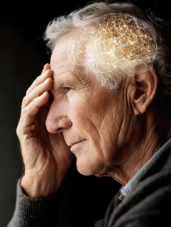 An older man in profile view holds his hand to his head, an illustration of a brain lights up, AI
