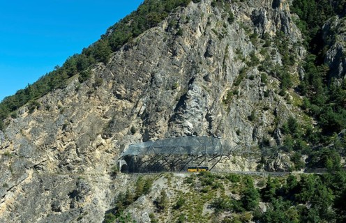 Yellow Swiss Post bus travelling under the safety nets against falling rocks to the Petits Pontis