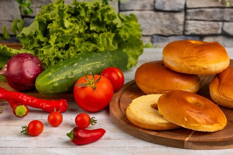 A selection of fresh ingredients such as tomatoes, cucumber, lettuce and bagels
