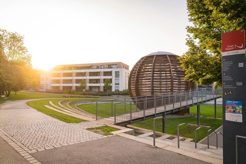 Modern architecture with a spherical building in the warm evening light, small town of Perle