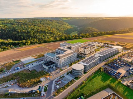 Large-scale building complex inspired by natural surroundings with hills and fields, new hospital
