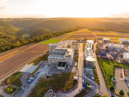 Building complex integrated into a rural environment with fields and trees, new hospital building,