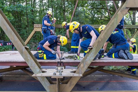 Construction of a temporary bridge over a slipped road crossing a stream, by the bridge