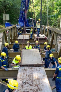 Construction of a temporary bridge over a slipped road crossing a stream, by the bridge