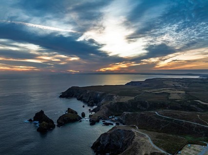 Sunset over Kynance Cove from a drone, Mount's Bay, Lizard Point, Cornwall, England, United Kingdom