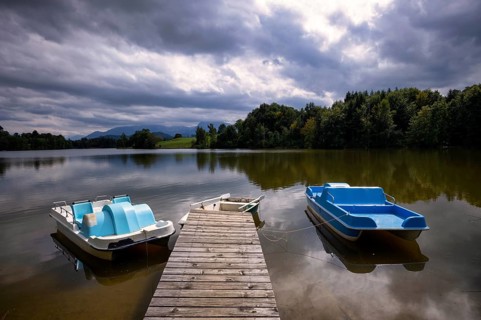 Rowing boat and pedal boats lying on a bathing jetty, jetty, wooden jetty, jetty, leads into a