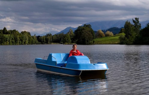 Woman, blonde, red jacket, riding pedal boat, bathing lake, lake, Schwaltenweiher near Seeg, Allgäu