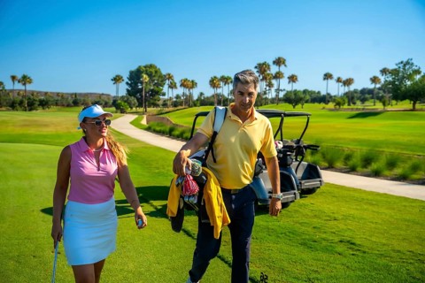 Golfers are walking on a beautiful golf course, carrying golf clubs and enjoying a sunny day of