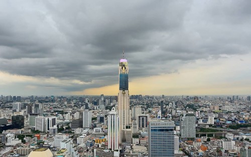 Bangkok cityscape featuring baiyoke tower ii standing tall amidst other buildings under a dramatic