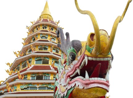 Colorful dragon statue standing in front of a traditional thai temple, showcasing the rich cultural